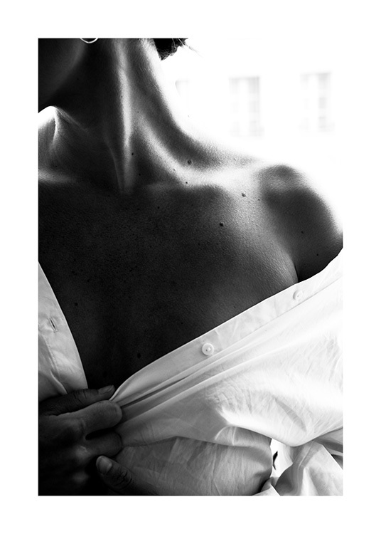  – Sort-hvidt fotografi af en bar skulder på en kvinde iført en hvid skjorte