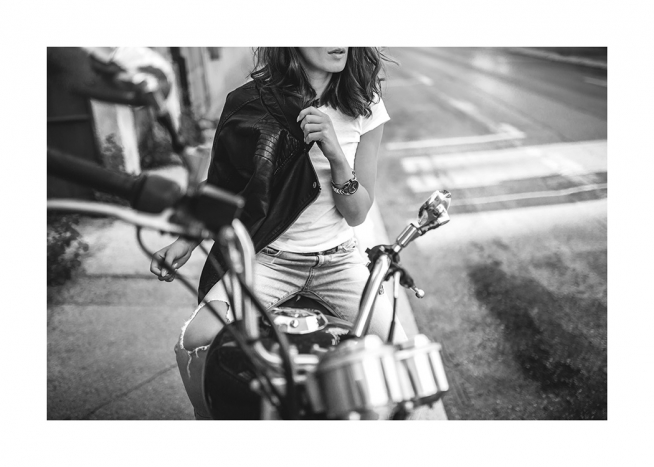 Sort-hvidt fotografi af en kvinde, der sidder på en motorcykel iført læderjakke