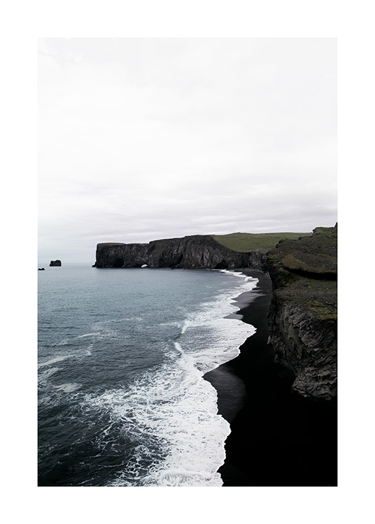  - Fotografi af kyst med sorte klipper, sort strand og bølger