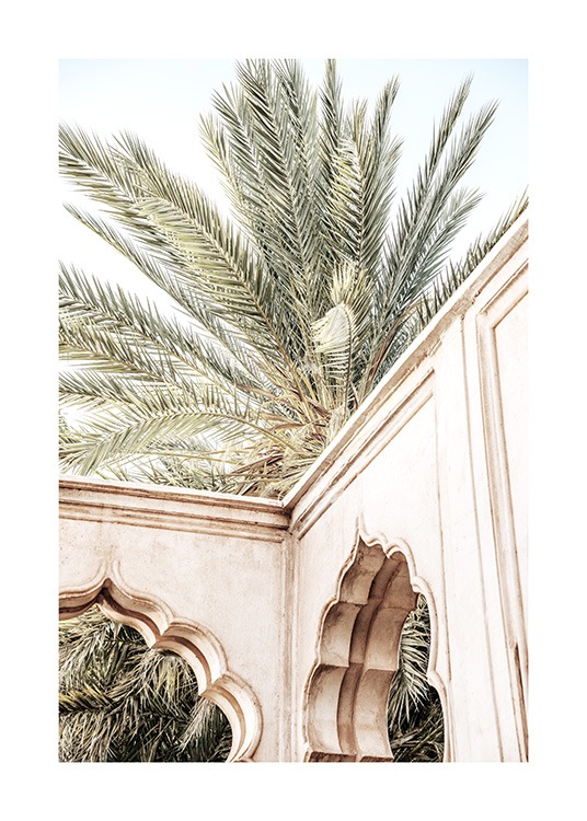  - Fotografi af en beige bygning med buer foran en palme