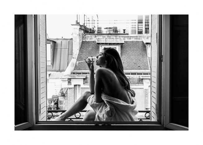  – Sort-hvidt fotografi af en kvinde, der sidder i et vindue og drikker et glas vin