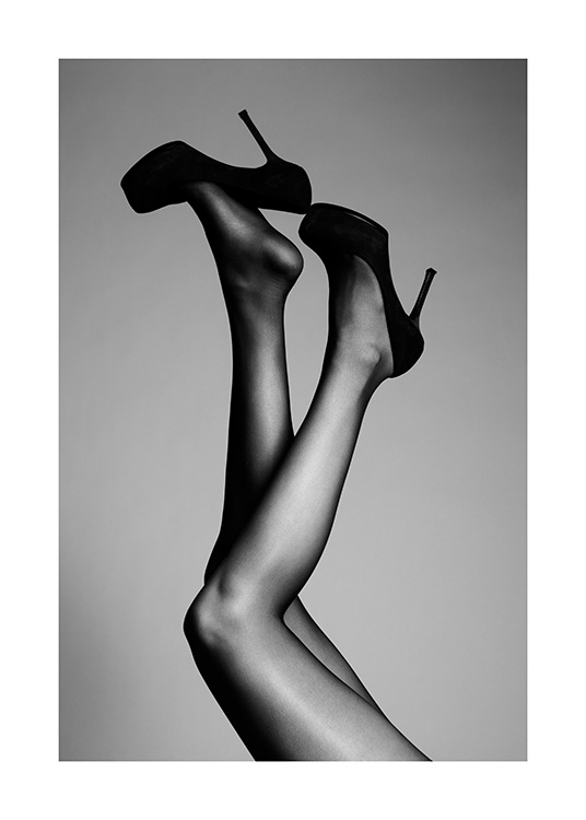  – Sort-hvidt fotografi af et par ben strakt op i luften med sorte højhælede sko
