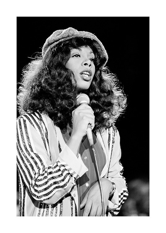  – Sort-hvidt fotografi af sangeren Donna Summer iført hat og stribet skjorte med en mikrofon i hånden