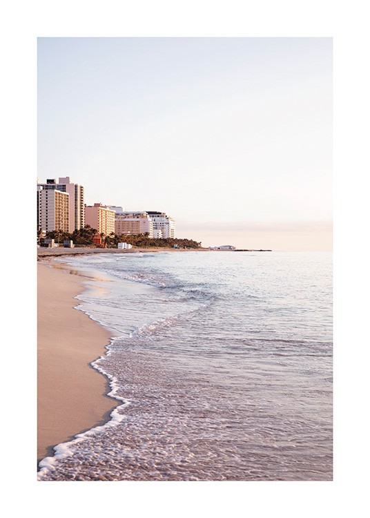  – Fotografi af bølger, der ruller op på en strand i Miami med bygninger i baggrunden