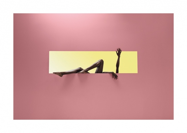  – Fotografi af en kvinde i et gult rektangel mod en lyserød baggrund, der strækker armene og benene ud