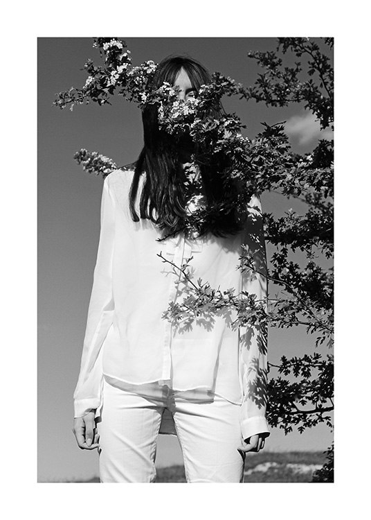  – Sort-hvidt fotografi af en kvinde i hvidt tøj med en gren foran sig