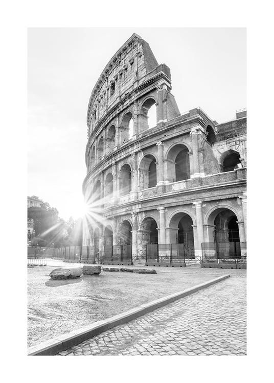  – Sort-hvidt fotografi af Colosseum i Rom med sollys i baggrunden