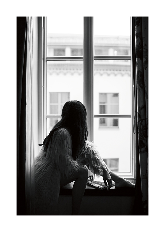 – Sort-hvidt foto af en mørkhåret kvinde, der sidder i en vindueskarm iført en jakke i imiteret pels