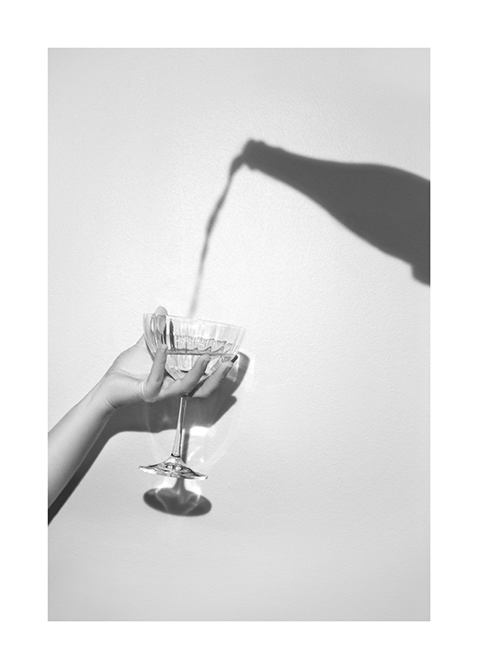  – Gråt fotografi af en skygge af en champagneflaske og en hånd, der holder et champagneglas