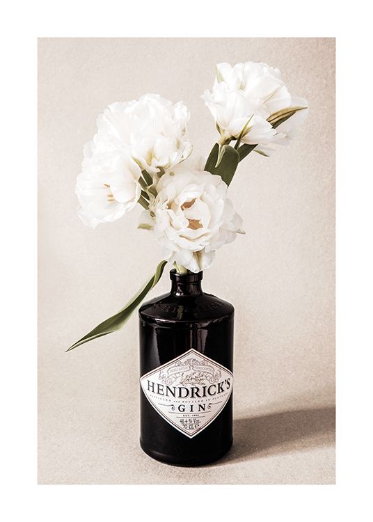  – Fotografi af hvide blomster i en sort ginflaske mod en beige, grynet baggrund