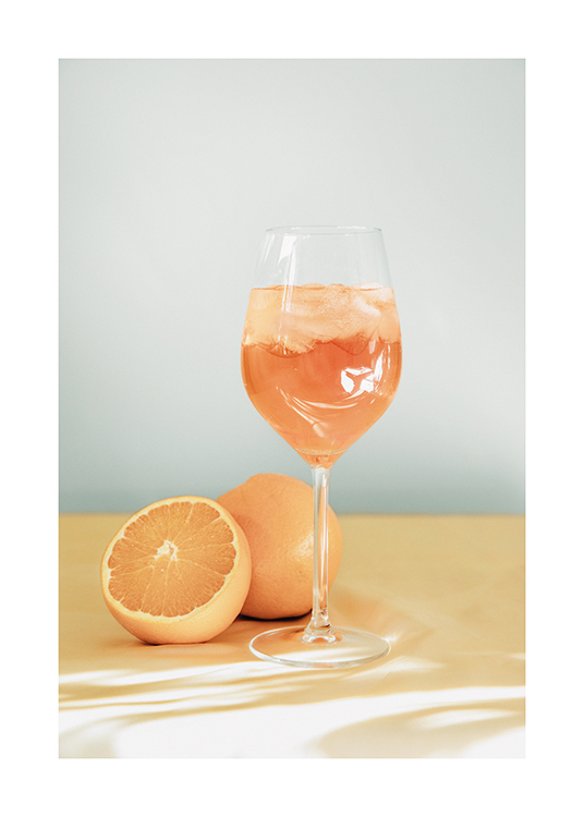  – Fotografi af Aperol Spritz i et vinglas med appelsiner, der ligger ved siden af glasset