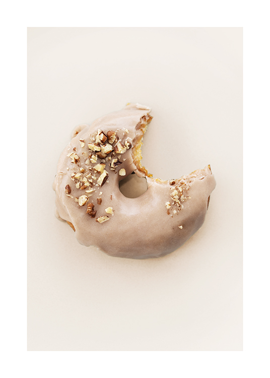  – Fotografi af en doughnut med beige glasur og hakkede nødder