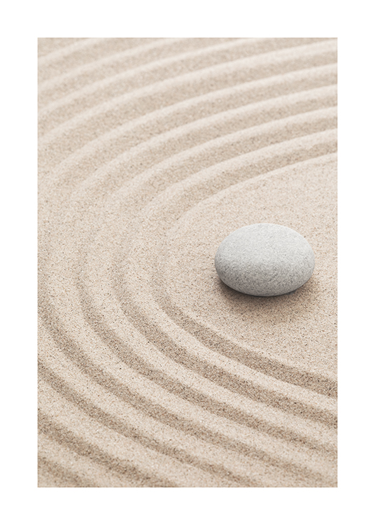  – Fotografi af mønstret sand med en grå sten, der ligger på det