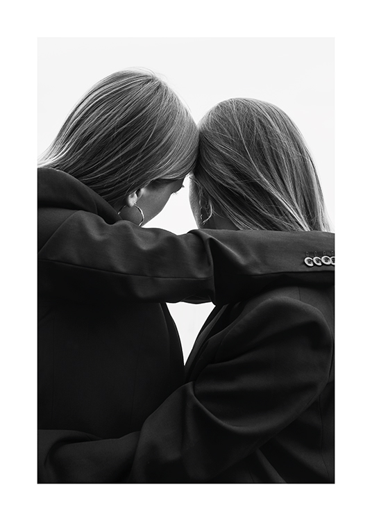  – Sort-hvidt foto af to kvinder i jakkesæt, der hviler hovederne mod hinanden