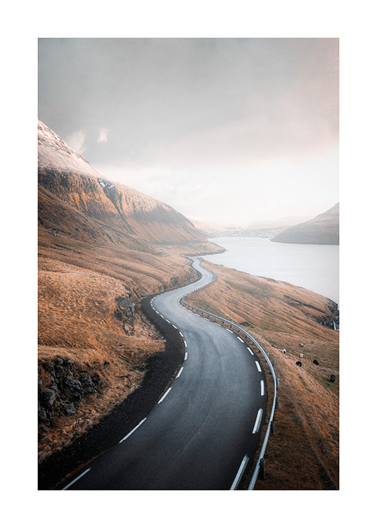  – Fotografi af et bjerglandskab med en vej i midten langs en sø