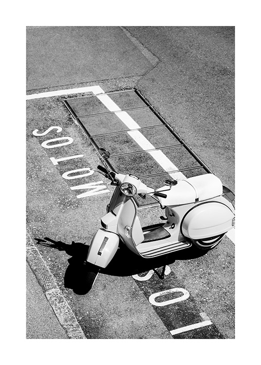  – Sort-hvidt fotografi af en retroscooter, der står på en parkeringsplads, hvor der er skrevet tekst på jorden