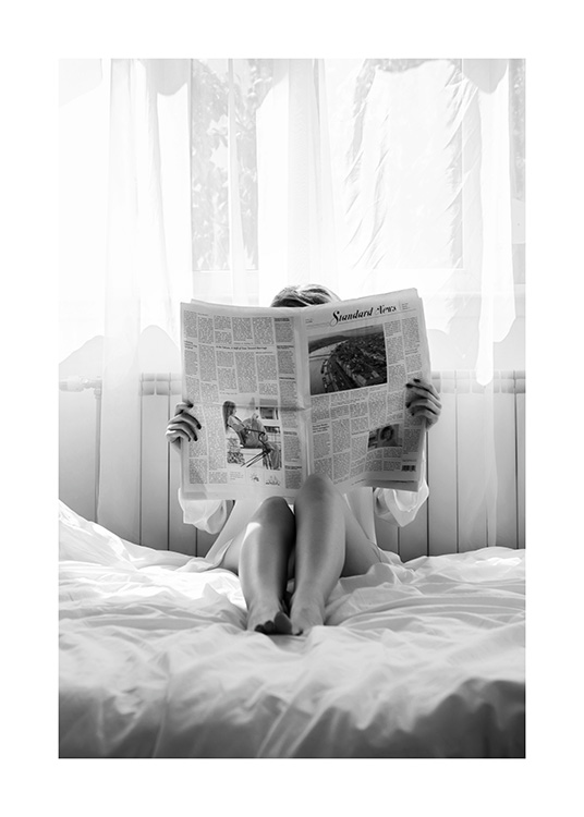  – Sort-hvidt fotografi af en kvinde, der læser avis i sengen