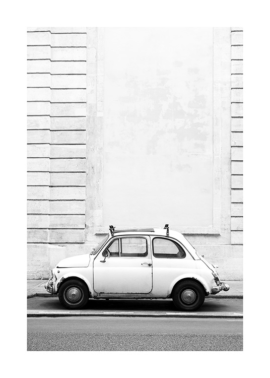  – Sort-hvidt fotografi af en lille retrobil, der er parkeret foran en bygning med stribeeffekter
