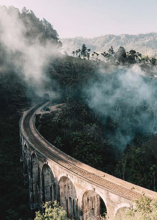  – Fotografi af en bro, der fører gennem et landskab med træer og tåge