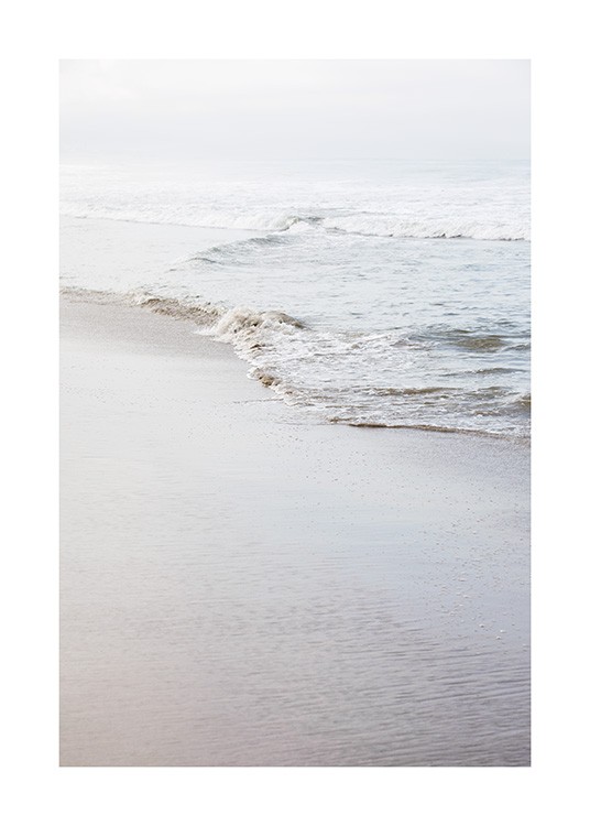  - Fotografi af en strand og en fredfyldt kystlinje med en lille bølge